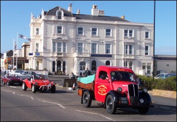 Vintage vehicles pass The Reed's Arms (formerly The Queens) in Burnham