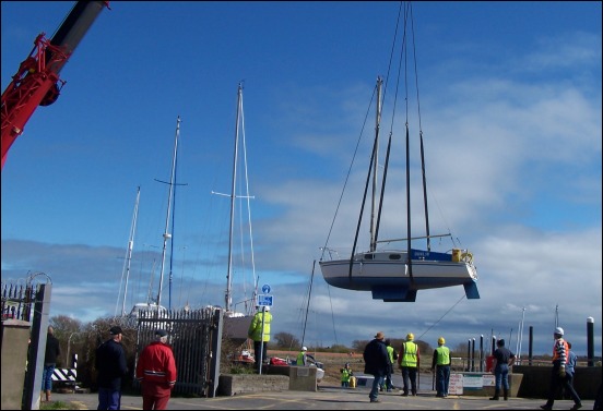 The crane winches another boat over to the beach