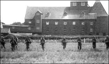Burnham-On-Sea Home Guard seen rehearsing an attack in front of Holt's Brewery