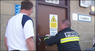 One of the fire crew tries to force open the door 