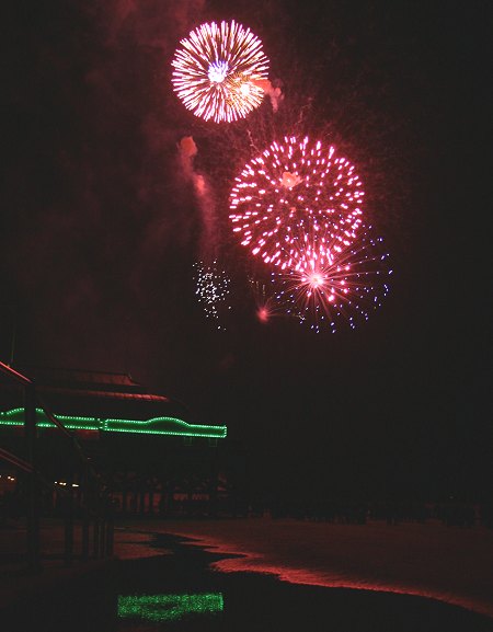 Fireworks over Burnham Pier reflected on a pool of sea water