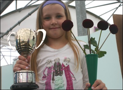 Gemma Andrews, 9, pictured with one her two trophies and her winning flower entry