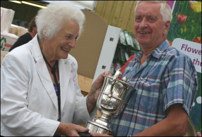Bert Sowe is handed one of the seven trophies he won at the Burnham Horticultural Show by one of the event's organisers, Mrs Beth Whetstone