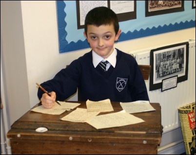 Chris Marsh, 7, sat at an old school desk