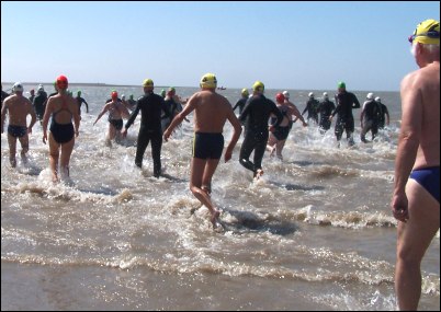 The 75 competitors race into the sea at the start of the race