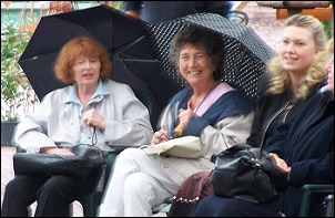 The crowds shelter under umbrellas at the start of the event