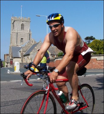 A cyclist dashes past St Andrew's Church during the 2005 Burnham Triathlon