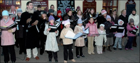 Waiting members of the public were entertained by carols from drama group Curtain Call