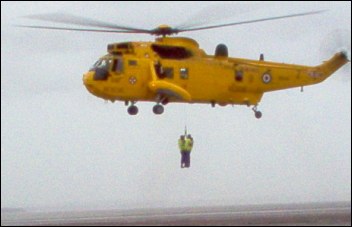 The RAF rescue helicopter lifts Burnham Coastguard members from the beach