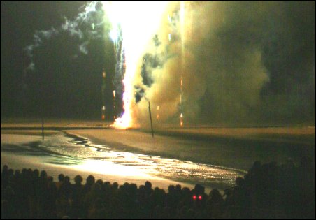 The crowds watch from the seafront as another firework erupts from Burnham-On-Sea  jetty