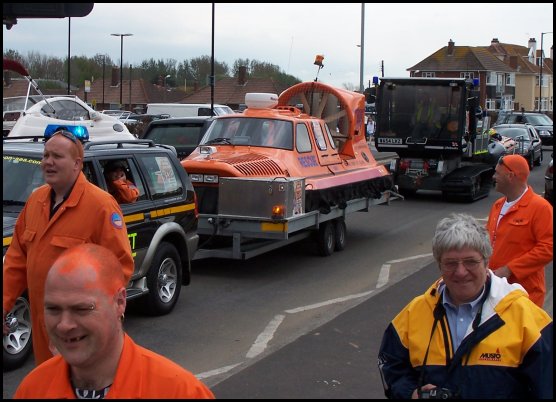 The hovercraft and RNLI D-Class boat being towed through the town with Adam Picton, Mike Lang and Alan Miller walking alongside