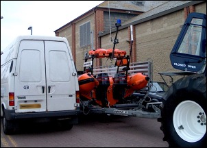 A white van blocks the passage of the lifeboat trailer