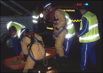 The Coastguard Mud Rescue Team prepare to load a stretcher onto the side of the hovercraft