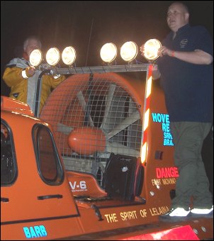 Crewmembers make last adjustments to the new searchlights