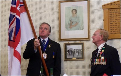 Cllr Jones, who is Chairman of the HMS Burnham Association, presents Cllr Davey with the white ensign