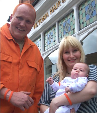 Alan Miller with his new orange hairstyle alongside salon owner Victoria Snook and her daughter Violet - all of whom are shown wearing their new orange wristbands