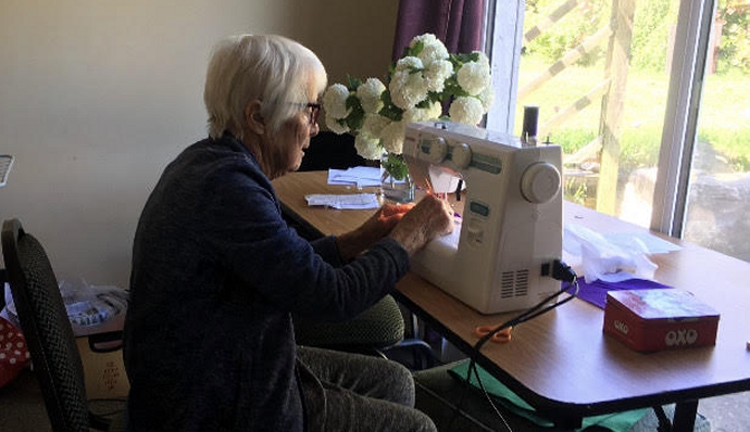 Pat Casey sewing scrubs at home