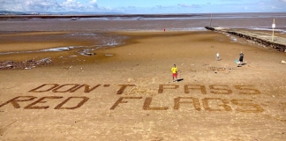 RNLI lifeguards use sand signage to keep beachgoers safe at Burnham-On-Sea