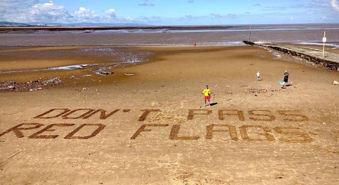 RNLI lifeguards use sand signage to keep beachgoers safe at Burnham-On-Sea