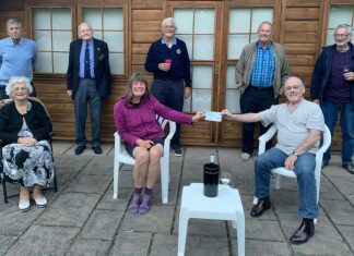 Burnham-On-Sea Rotary President Terry handing over a cheque donation of £100 to Karen Penny.