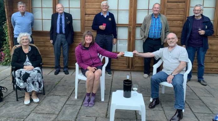 Burnham-On-Sea Rotary President Terry handing over a cheque donation of £100 to Karen Penny.