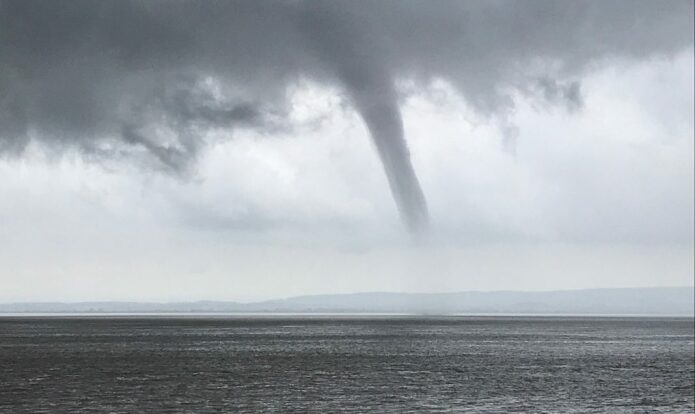 Waterspout photographed forming over the waters of the ...