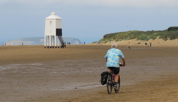 Cyclist cycling along Burnham-On-Sea beach