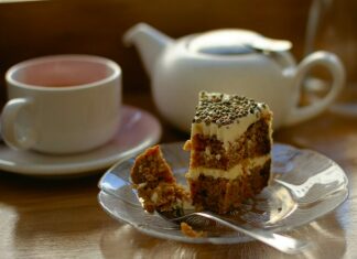 white and brown cake on white ceramic saucer beside pink ceramic teacup